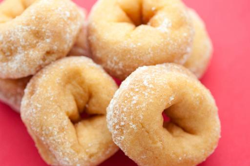 Golden soft freshly baked or deep fried ring doughnuts sprinkled with sugar for an unhealthy but tasty breakfast