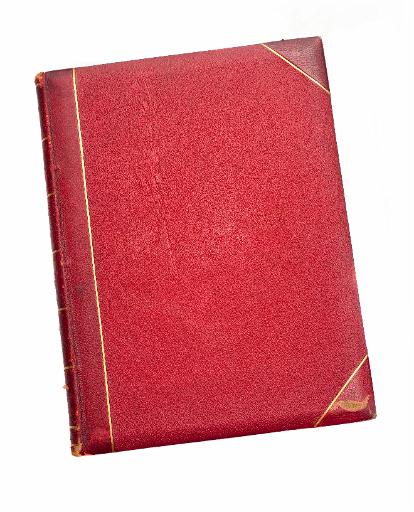 Old scuffed red book with leather binding and gilt tooling lying isolated on a white surface