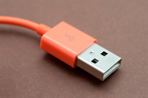 Red USB cable and plug for connecting peripherals and computer hardware to allow for data transfer