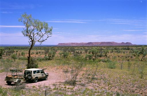 4x4 vehicle towing a trailer parked under a small tree overlooking an expanse of beautiful scenic countryside while out enjoying an Australian outback safari