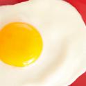 Delicious single fried egg with a deep yellow yolk on a red plate for breakfast, close up overhead view